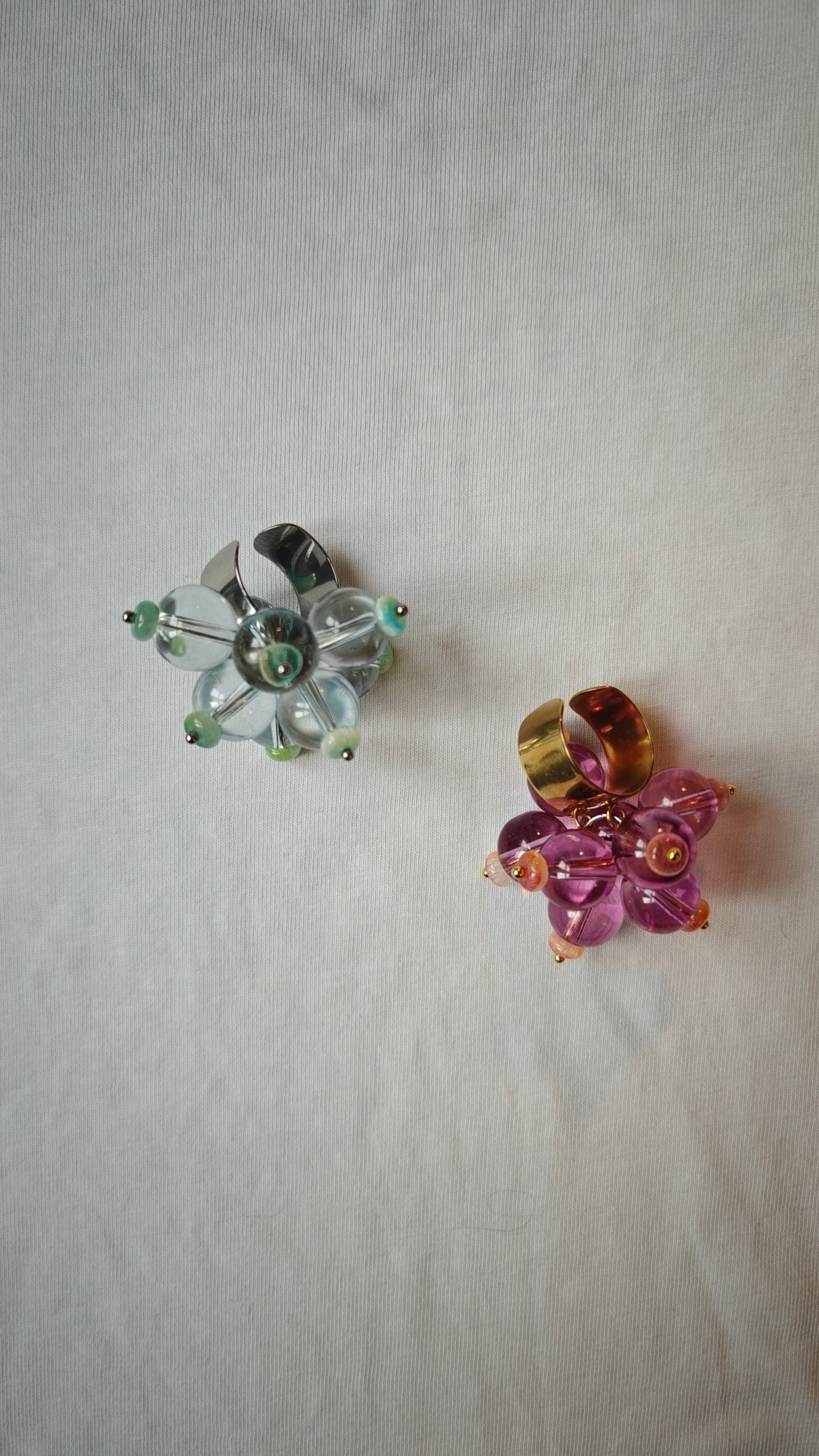 Bague turquoise et bague rose et violet dorée posées côte à côte