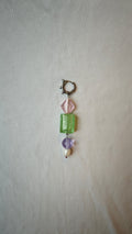 Mono boucle d'oreille avec un losange rose, un rectangle vert, une perle lilas et une perle blanche, avec anneau à pics