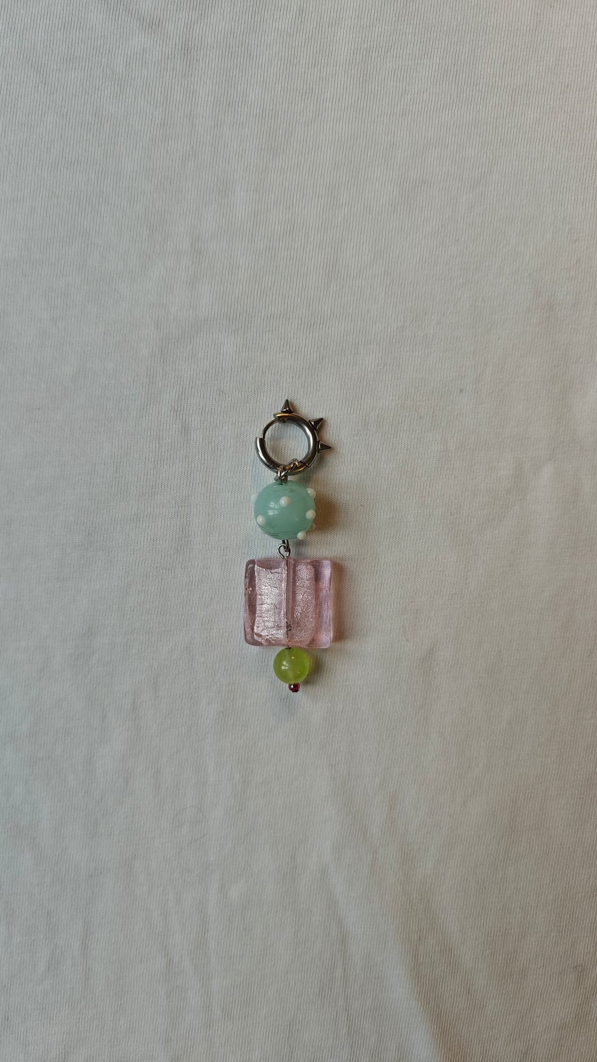 Mono boucle d'oreille avec une perle vert d'eau à pois blancs, un carré rose et une perle vert anis, avec anneau à pics